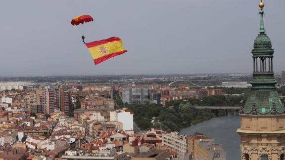 Una bandera de España gigante sobrevuela la plaza del Pilar ante la mirada de los zaragozanos