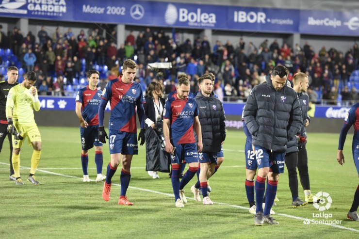 Varios jugadores del Huesca se retiran del césped tras perder 2-6 con el Valencia.