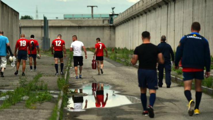 Presos caminan hacia el campo de rugby en una prisión