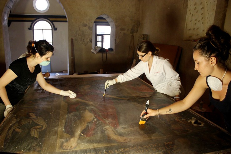 Varias restauradoras de la Fundación Tarazona Monumental, restaurando un lienzo