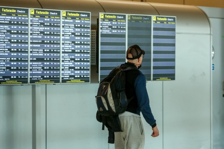 Un hombre mira las pantallas de información sobre vuelos en un aeropuerto.