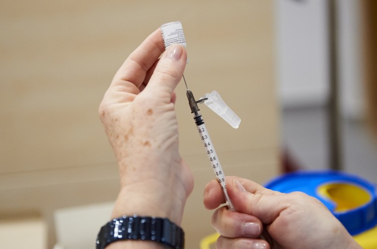 Una trabajadora sanitaria sostiene una jeringuilla con la vacuna de Pfizer-BioNTech.