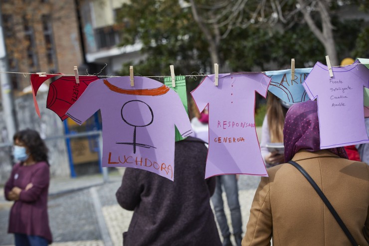 Varias mujeres cuelgan ropa de papel con mensajes simulando una colada (Madrid)