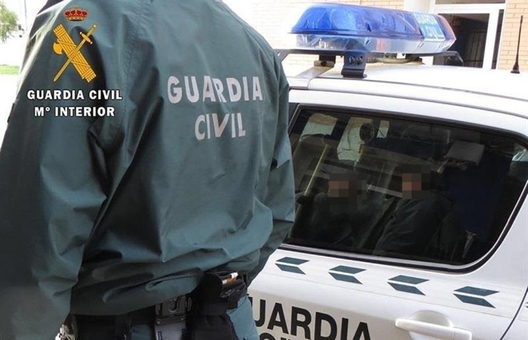 Agente de la Guardia Civil junto a un vehículo policial. / Guardia Civil