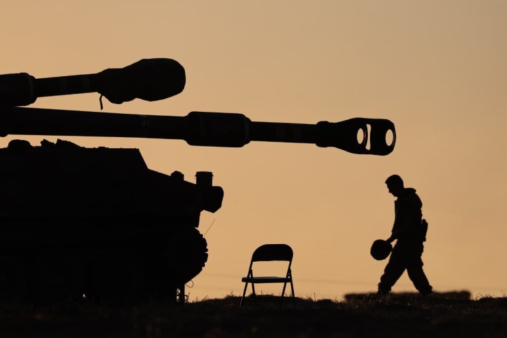 Un soldado israelí de artillería camina bajo el atardecer en la frontera con Gaza (EFE).