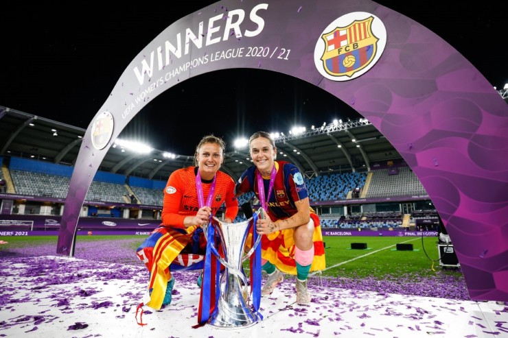 Mapi León, a la derecha, posa con el trofeo de la Champions League femenina con una bandera de Aragón a la cintura. Foto: FC Barcelona