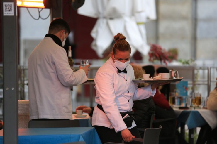 Una camarera, sirviendo en una terraza.