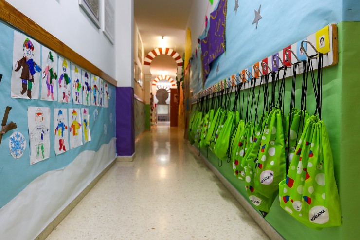 Pasillo con dibujos y mochilas colgadas en un centro de Educación Infantil (EP).