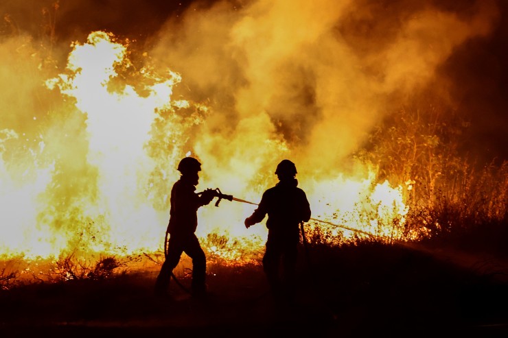 Dos bomberos, trabajando para sofocar un incendio (EFE).