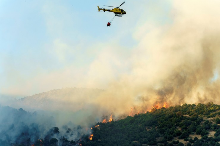 Un helicóptero, en la labores de extinción del incendio declarado en el término de El Tiemblo, en Ávila (EP).