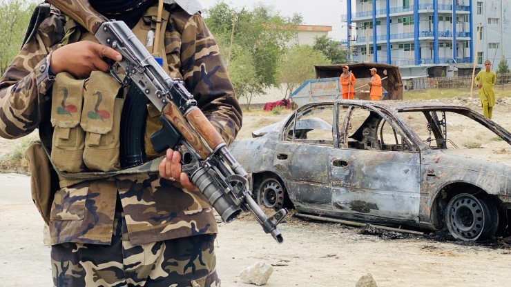 Un talibán permanece cerca del vehículo utilizado para realizar una explosión cerca del aeropuerto de Kabul.