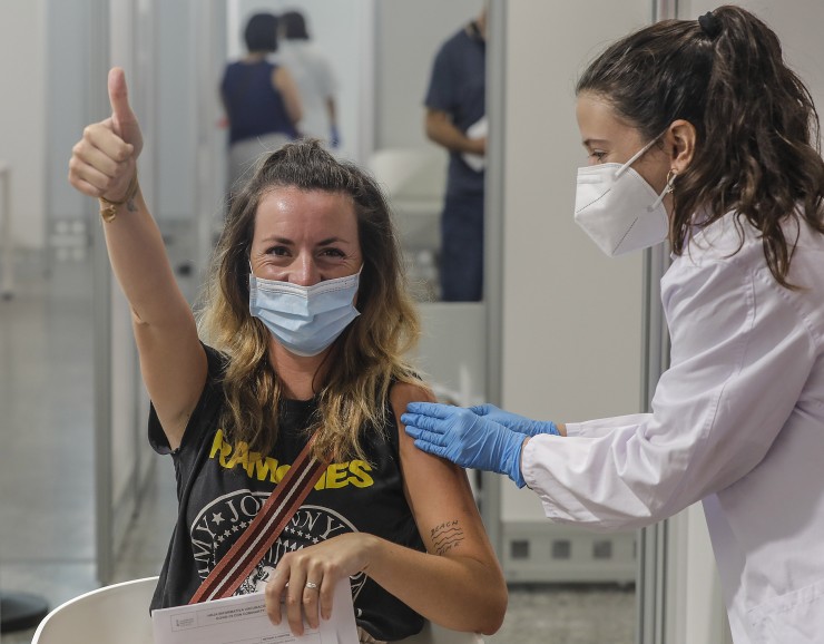 Una mujer levanta su dedo pulgar mientras recibe la vacuna contra la COVID-19 (EP).