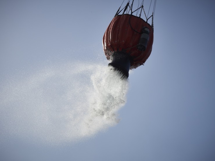 Un helicóptero lanza agua para sofocar un incendio (EP).