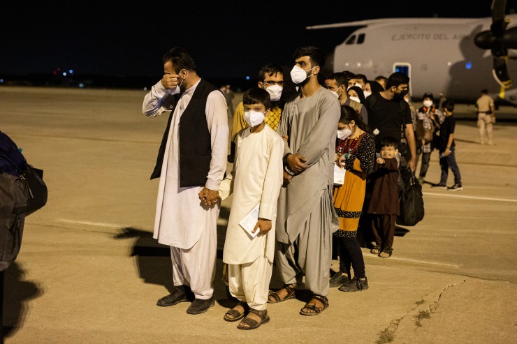Un hombre emocionado acompañado de varias personas a su llegada a la pista tras bajarse del avión A400M en el que ha sido evacuados de Kabul (EP).