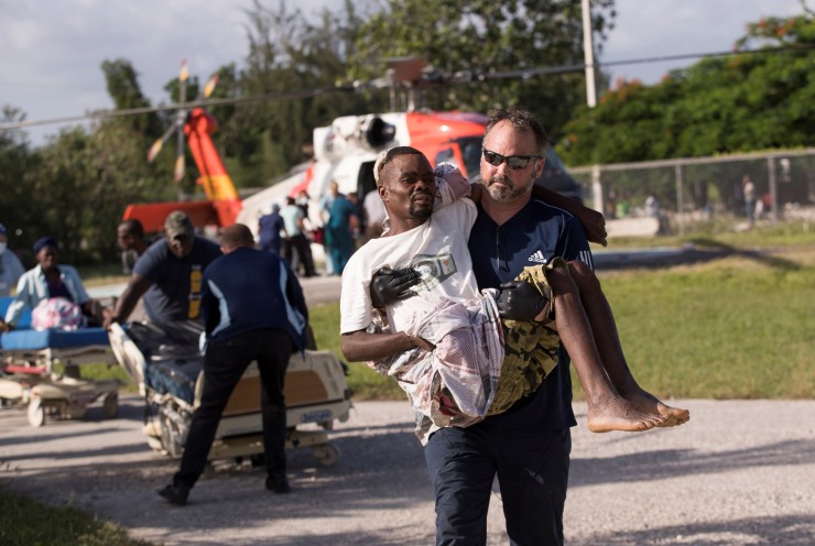 Un sanitario traslada a un hombre herido por el terremoto (Haití).