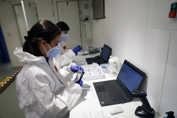 Dos personas analizando pruebas PCR de la COVID-19 (EP).