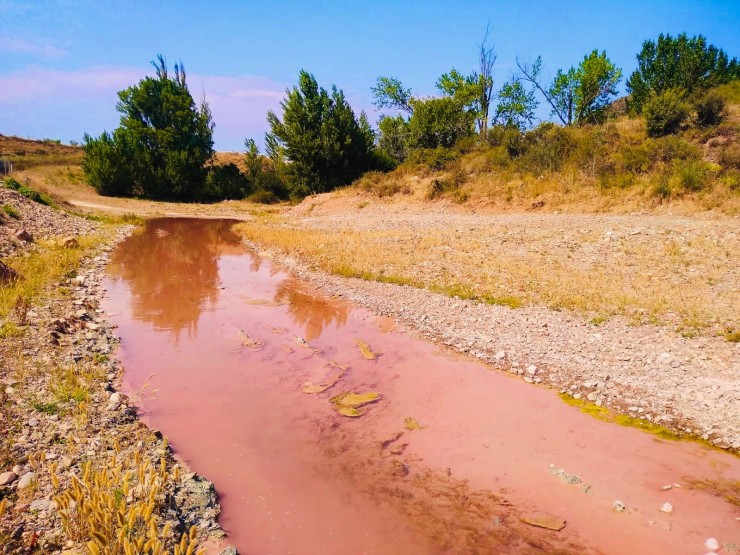 El río Grío, teñido de rojo por el vertido según se denuncia (Ayuntamiento de Morata).