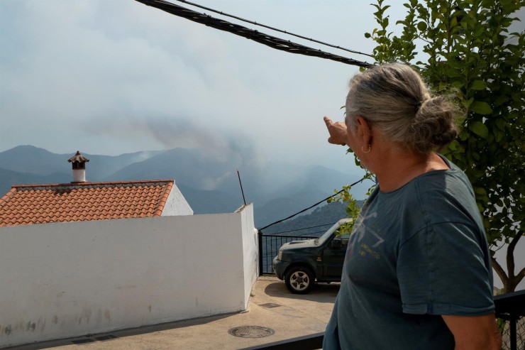 Un vecino de Algatocín (Málaga), muestra la columna de humo del incendio de Sierra Bermeja (EFE).