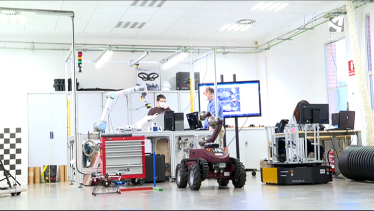 Dos investigadores rodeados de aparatos e instrumentos de trabajo en su laboratorio.