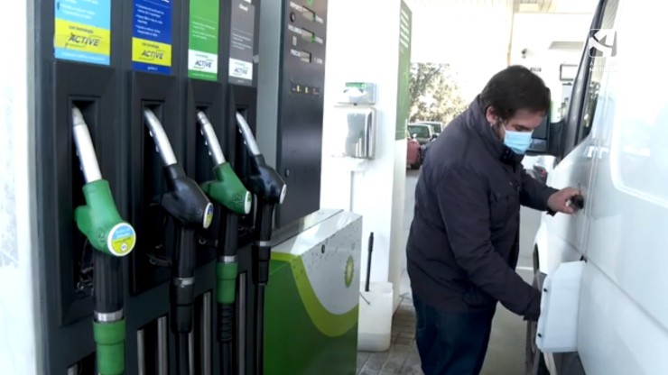 Un hombre echa gasolina en una estación de servicio.
