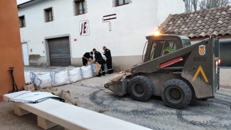 Efectivos de la UME colocan sacos de tierra en una calle de Novillas para bloquear la llegada del agua a su casco urbano.