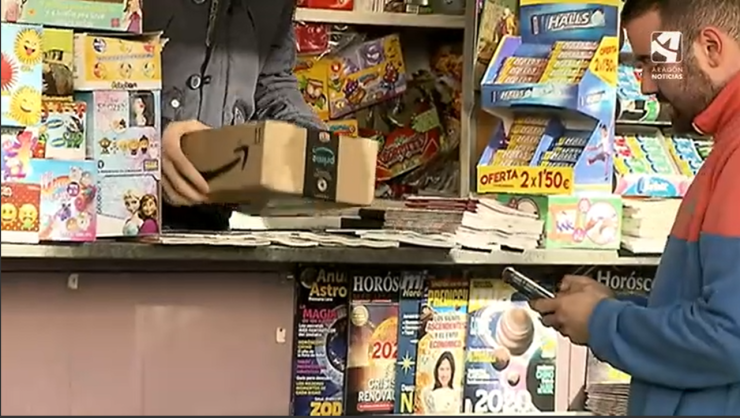 Un cliente recoge un paquete de Amazon de manos de un repartidor.