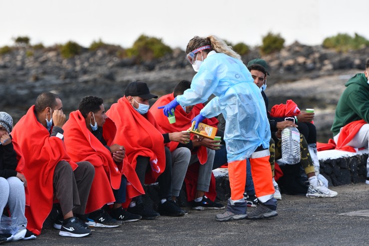 (Imagen de archivo) Una voluntaria de la Cruz Roja atiende a un grupo de migrantes en Tenerife. / EFE