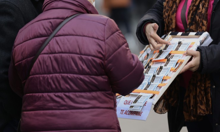 Una mujer compra un décimo de lotería a una vendedora ambulante. / Europa Press