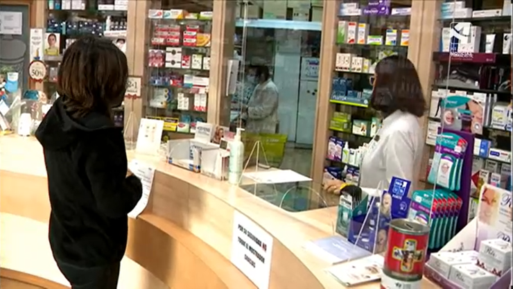 Una clienta frente al mostrador de una farmacia aragonesa.