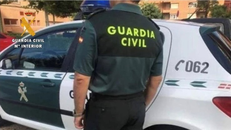 Un agente junto a un vehículo de la Guardia Civil (imagen de archivo). / Guardia Civil