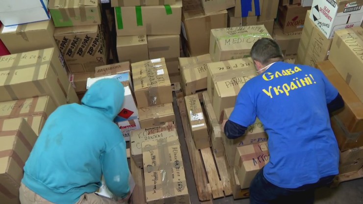 Voluntarios organizan cajas en una nave de Cuarte.