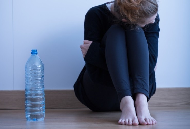Una mujer sentada junto a una botella de agua. / Foto: EP.