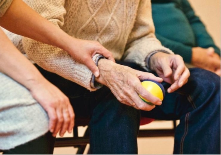 Imagen de las manos de una persona mayor sujetando una pelota. / Foto: EP