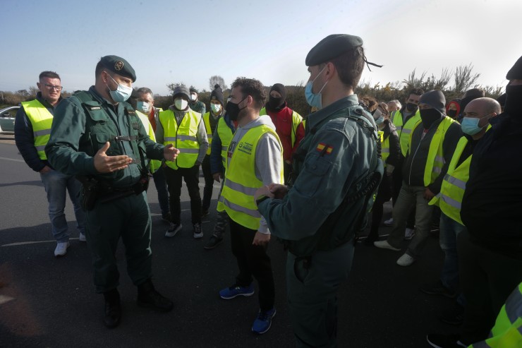 Dos agentes de la Guardia Civil hablan con los miembros de un piquete en Galicia. / Foto: EP.