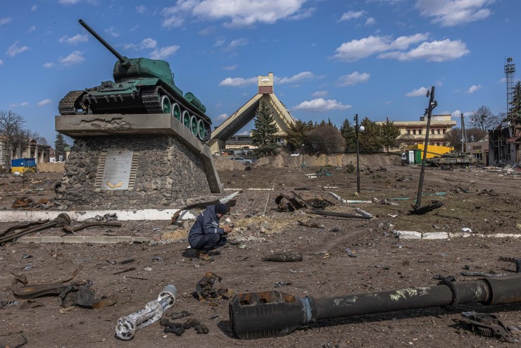 Un rescatista ucraniano examina un objeto explosivo junto a partes de vehículos militares rusos destruidos. (EFE/Roman Pilipey).