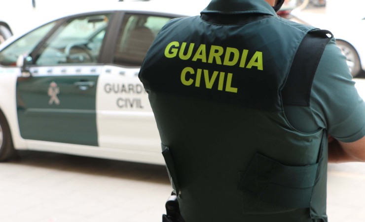 Un agente de la Guardia Civil, de espaldas, junto a un vehículo oficial. / Europa Press