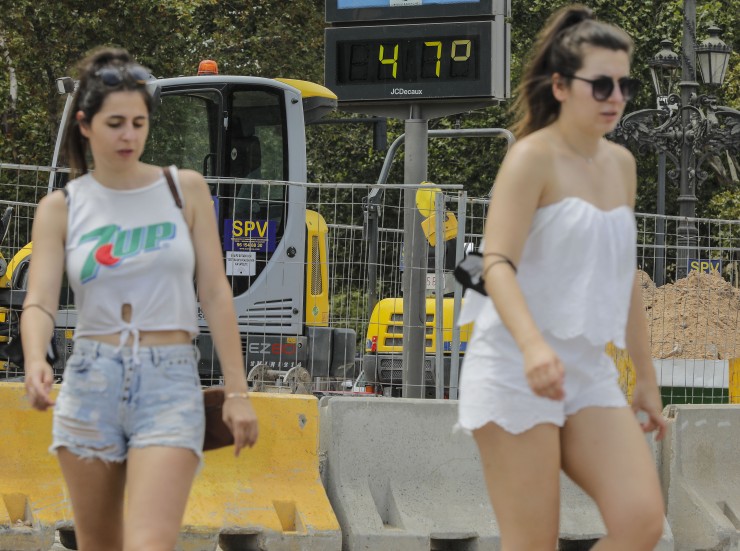 Dos chicas caminan cerca de un termómetro que marca 47 grados. / Europa Press