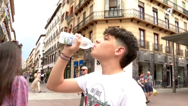 Un joven se hidrata para contrarrestar las altas temperaturas.