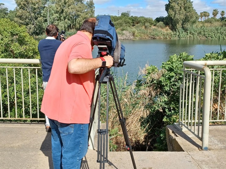 Unos cámaras graban el lugar donde se encontró el cadáver de la mujer, en el río Guadalquivir, en Sevilla. / EFE