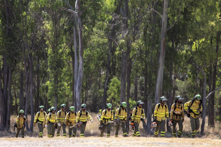 Varios operarios regresan de las tareas de extinción en Benahavís (Málaga), una de los municipios afectados junto a Júzcar en el incendio forestal de Pujerra. (EFE/Daniel Pérez).