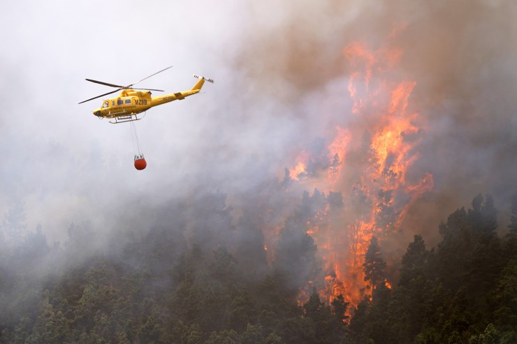 Un helicóptero contra incendios descarga agua sobre un incendio forestal en Tenerife Norte el pasado sábado. (Europa Press)