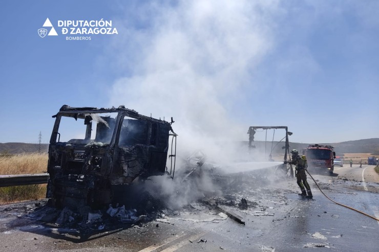 Un bombero apaga el fuego de uno de los camiones. / Diputación de Zaragoza.