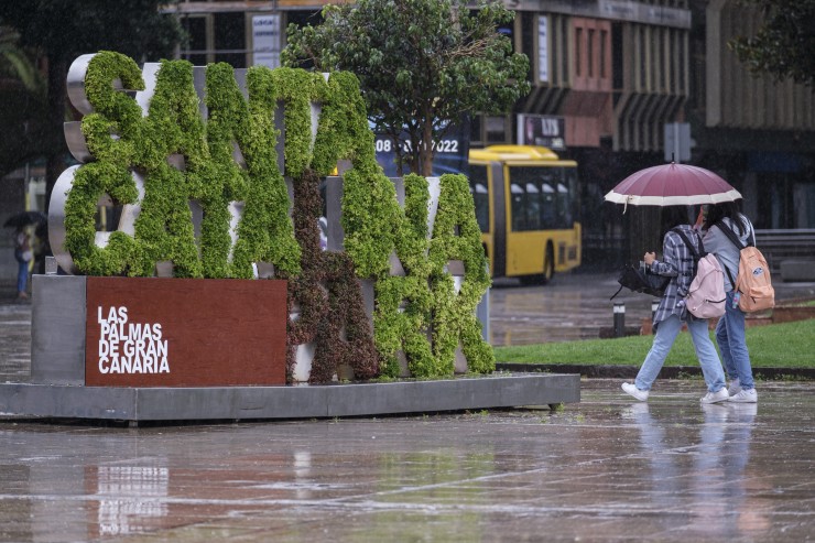 Dos personas caminan bajo un paraguas en Las Palmas de Gran Canaria. / EFE