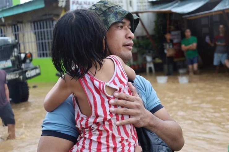 Un policía sujeta a una niña en la operación de rescate en la ciudad de Parang, Maguindanao (Filipinas), afectada por las inundaciones / Foto: Oficina Regional de la Policía Autónoma de Bangsamoro (BAPRO).