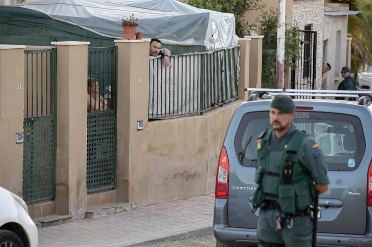 Varios agentes de la Guardia Civil, en la puerta del domicilio donde fue hallado el cadáver. / EFE-Marcial Guillén