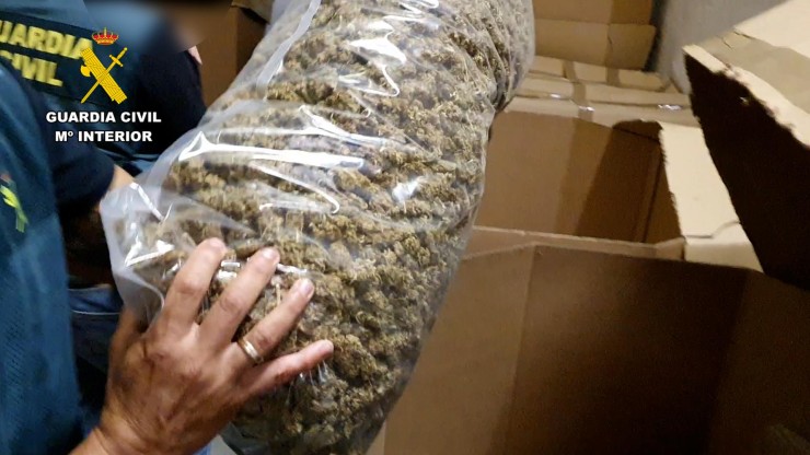 Un agente muestra uno de los paquetes de marihuana incautado. / Guardia Civil