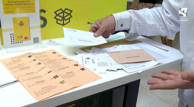 Un votante con documentación electoral en una oficina de Correos.