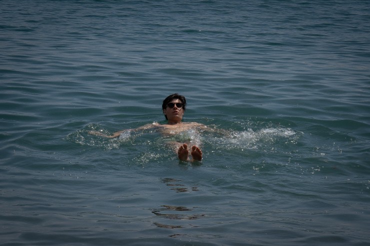 Un hombre se da un baño en la playa de la Barceloneta, en abril de 2023, en Barcelona. / Europa Press