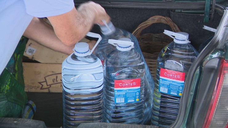 Un vecino de Tarazona carga varias garrafas de agua en su coche.