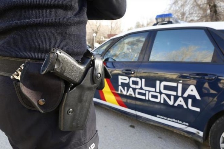 Un agente de la Policía Nacional junto al coche patrulla. / Europa Press